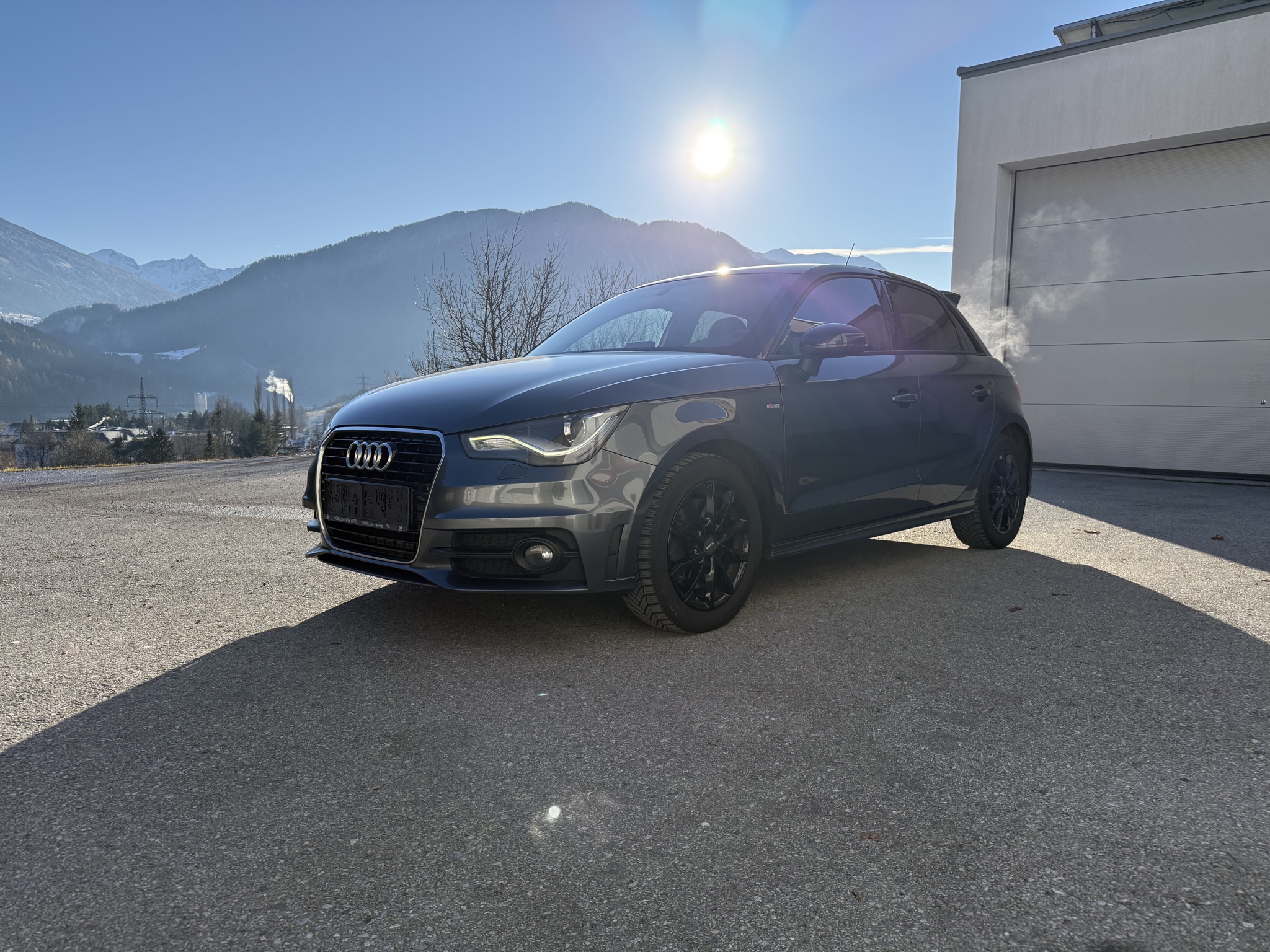 Dunkler Audi A1 Sportback vor Bergkulisse
