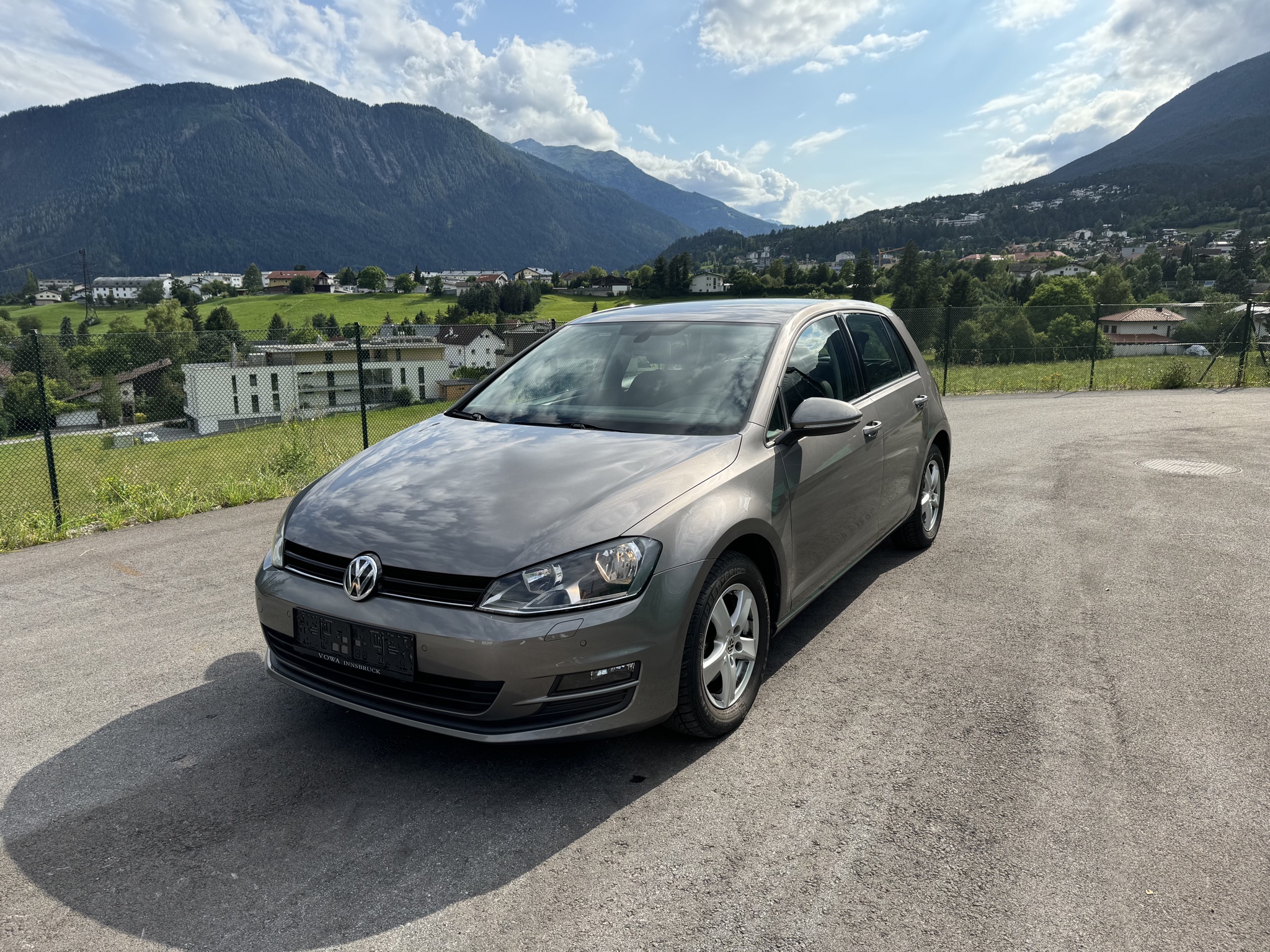 Grauer VW Golf vor Tiroler Bergkulisse